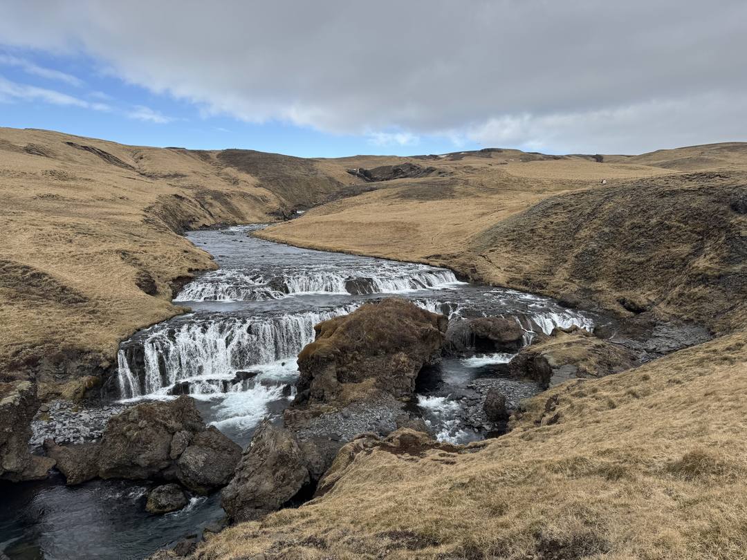 A small waterfall in a green valley near Skógar on the South Coast